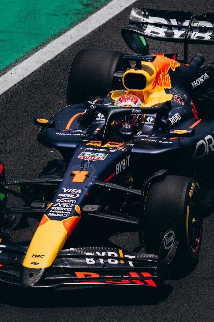 services-02 Overhead view of a Formula 1 car racing on a track, displaying vibrant sponsor logos.